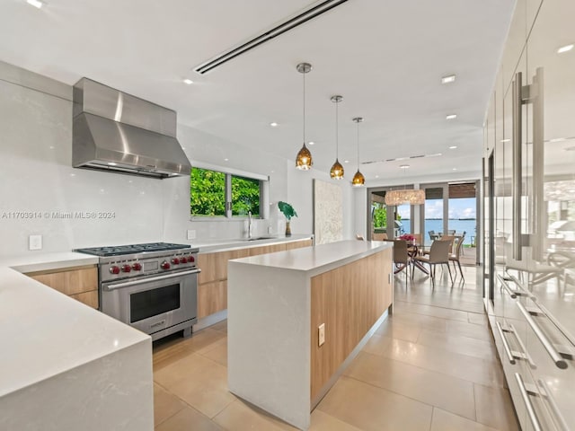 9301 N Bayshore Dr, Miami Shores, FL 33138 - kitchen featuring modern cabinets, wall chimney range hood, designer range, light brown cabinets, and light countertops