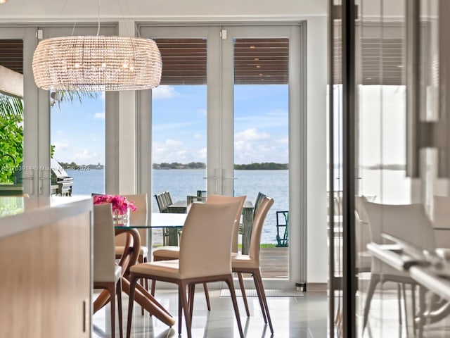 interior space featuring a notable chandelier, a water view, and french doors