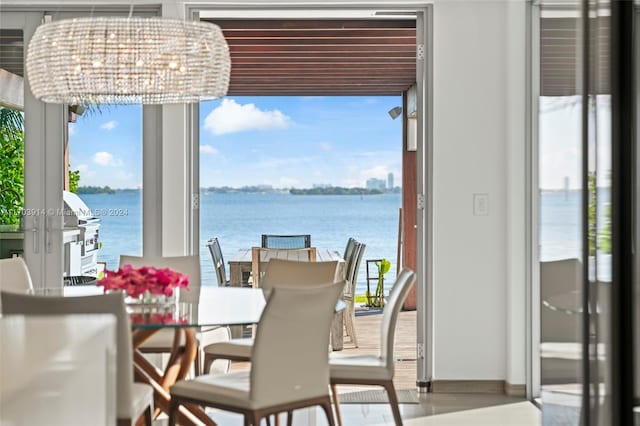 dining room with a water view and a notable chandelier