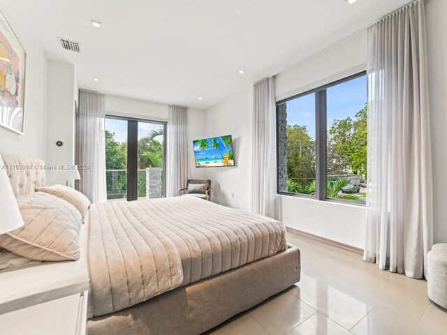 9301 N Bayshore Dr, Miami Shores, FL 33138 - bedroom with light tile patterned floors and access to outside