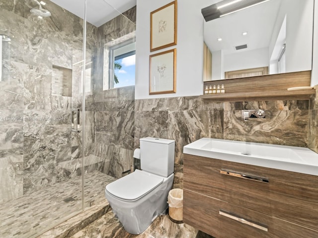 bathroom featuring a shower with door, vanity, tile walls, and toilet