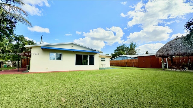 back of property with a gazebo and a lawn