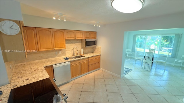 kitchen featuring decorative backsplash, sink, light tile patterned floors, and stainless steel appliances