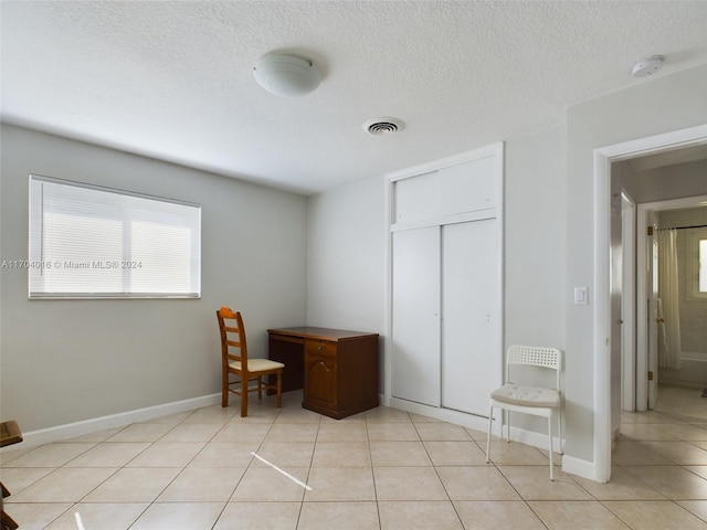 office space featuring light tile patterned floors and a textured ceiling