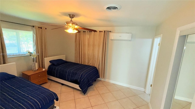 bedroom featuring ceiling fan, light tile patterned floors, and a wall unit AC