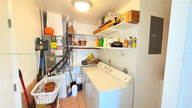 clothes washing area with electric panel, heating unit, light tile patterned floors, and washer and dryer