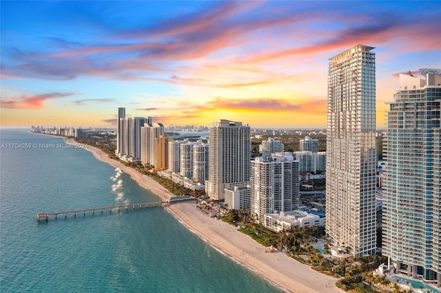 aerial view at dusk with a beach view and a water view