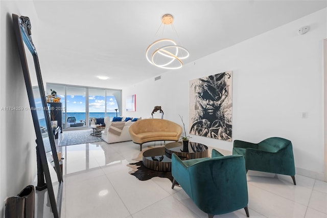 living room with a wall of windows, light tile patterned floors, visible vents, and a notable chandelier