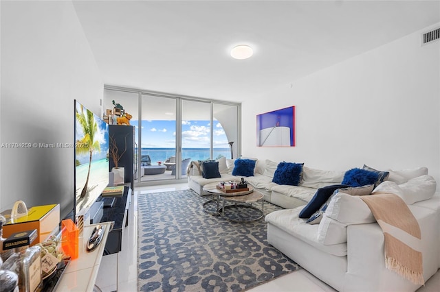 living room featuring visible vents and a wall of windows