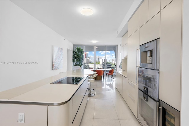 kitchen featuring light countertops, modern cabinets, light tile patterned flooring, and black electric stovetop
