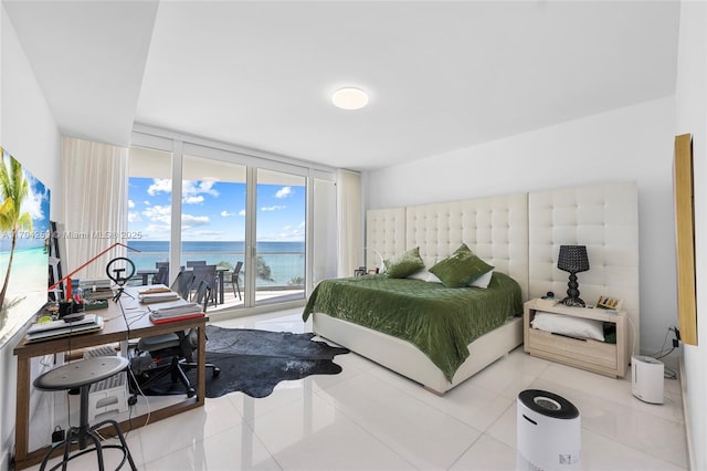 bedroom with a wall of windows, tile patterned floors, and a water view