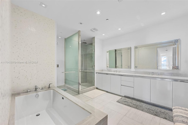 bathroom featuring vanity, tile patterned flooring, plus walk in shower, and tile walls