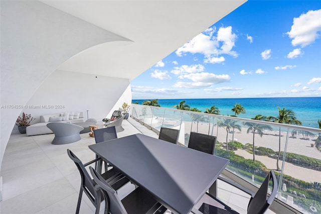 balcony with a water view and a view of the beach