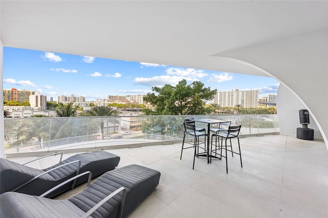 view of patio / terrace with a view of city and a balcony