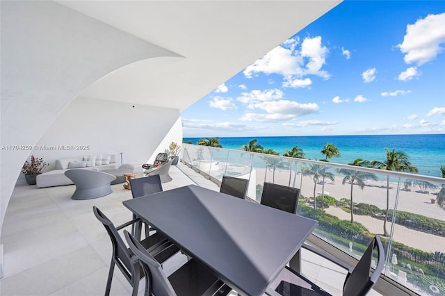 balcony with outdoor dining area and a water view