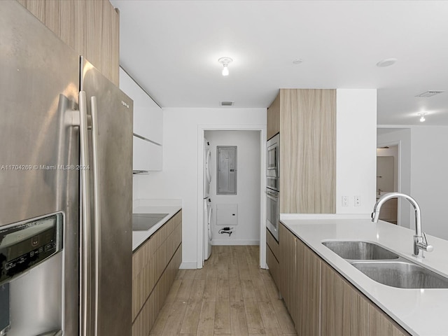 kitchen featuring sink, light wood-type flooring, and appliances with stainless steel finishes