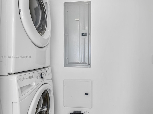 washroom with electric panel and stacked washing maching and dryer