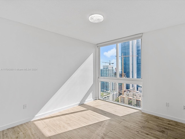 empty room featuring hardwood / wood-style flooring and a wall of windows