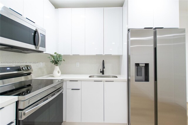 kitchen featuring sink, white cabinets, and stainless steel appliances