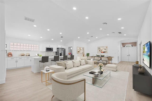 living room with lofted ceiling and light hardwood / wood-style flooring