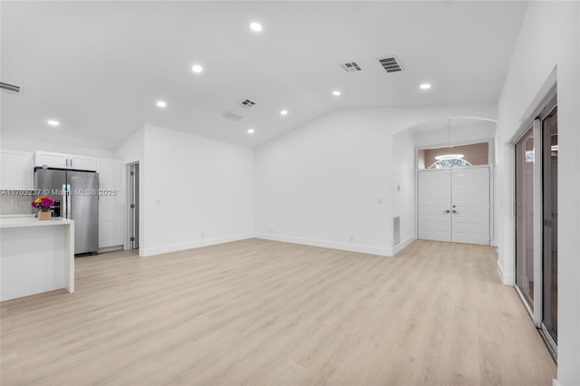 unfurnished living room with lofted ceiling and light hardwood / wood-style floors