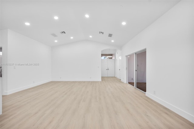 spare room with vaulted ceiling and light hardwood / wood-style floors