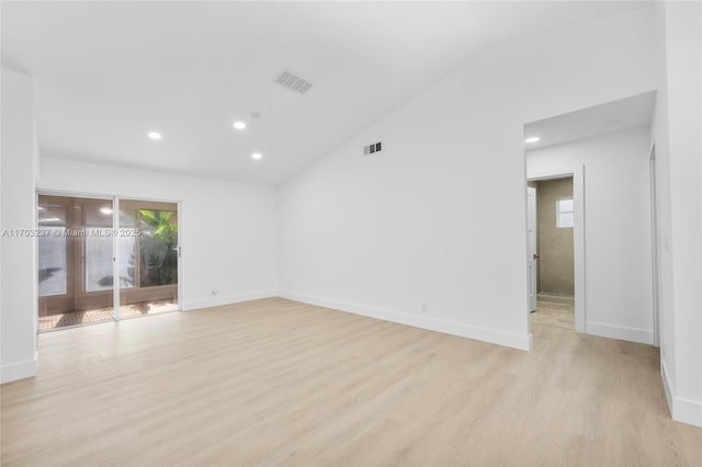 unfurnished room with lofted ceiling and light hardwood / wood-style flooring