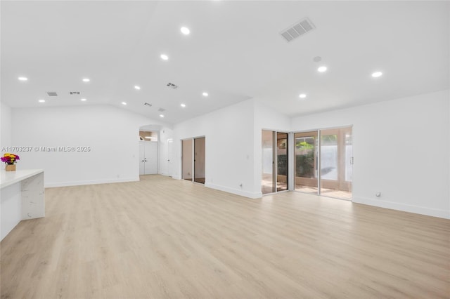 unfurnished living room featuring light hardwood / wood-style flooring and lofted ceiling