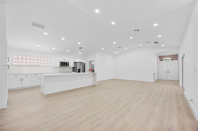 unfurnished living room with vaulted ceiling and light hardwood / wood-style floors