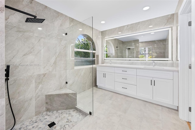 bathroom featuring vanity, tiled shower, and a healthy amount of sunlight