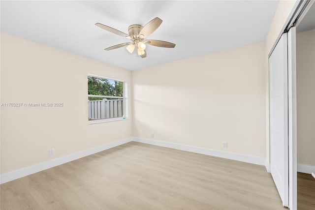 unfurnished bedroom featuring light wood-type flooring, ceiling fan, a closet, and a barn door