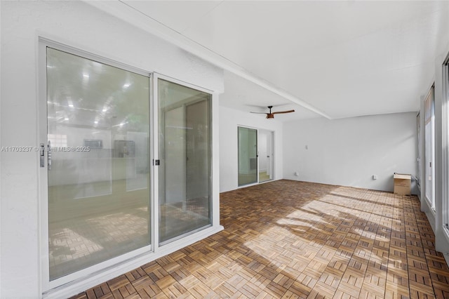 unfurnished sunroom featuring ceiling fan