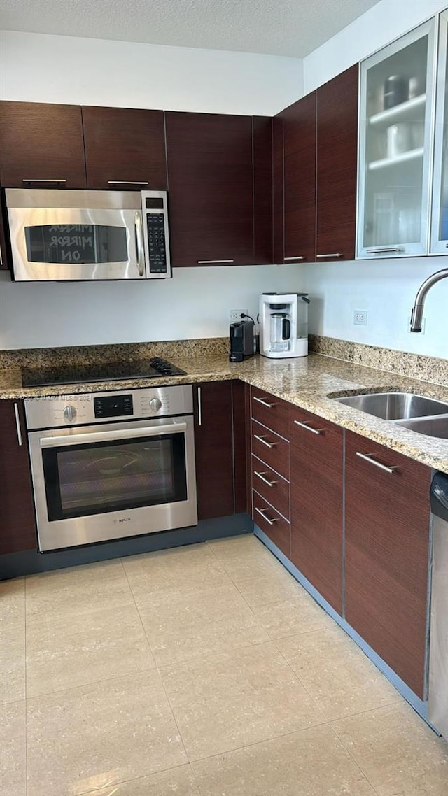 41 SE 5th St Unit 2011, Miami, FL 33131 - kitchen with stainless steel appliances, a sink, dark brown cabinets, and light stone countertops