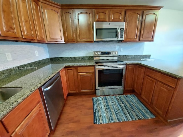 kitchen featuring light hardwood / wood-style floors, light stone counters, and appliances with stainless steel finishes