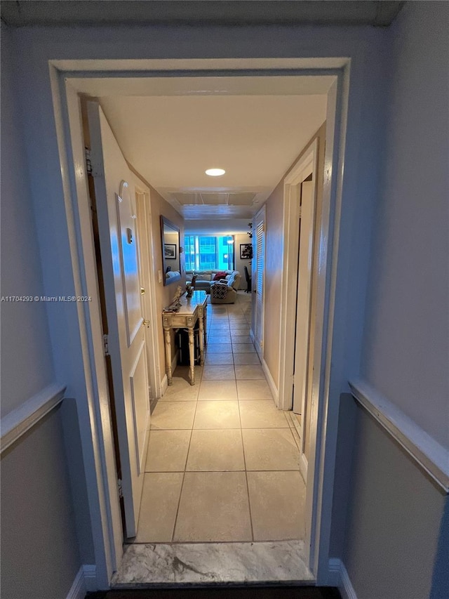 hall with light tile patterned floors