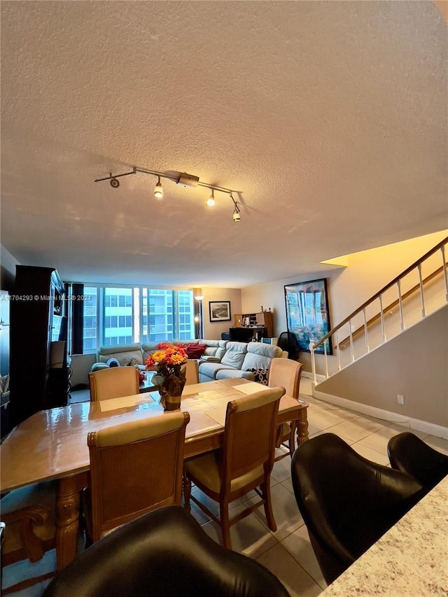 dining room featuring light tile patterned flooring, track lighting, and a textured ceiling