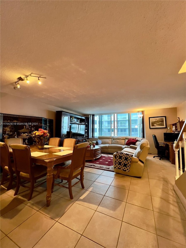 dining area featuring light tile patterned floors and a textured ceiling