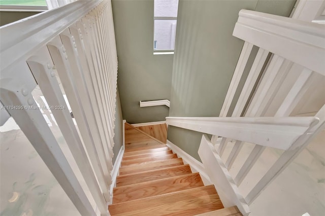 stairway featuring a wealth of natural light and wood-type flooring