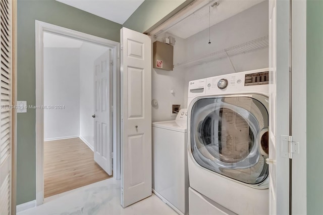 clothes washing area with washer and clothes dryer and light hardwood / wood-style floors