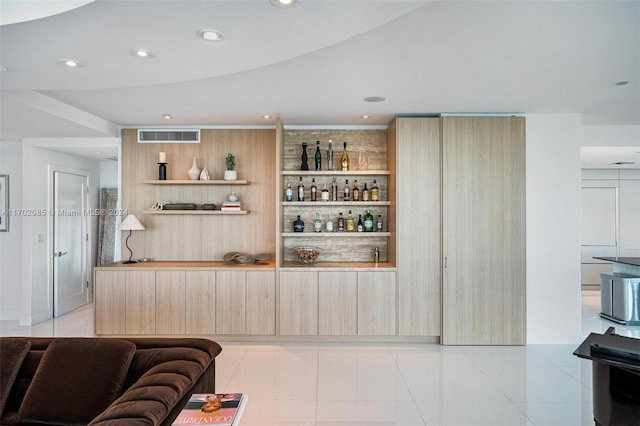 bar featuring light brown cabinetry and light tile patterned floors