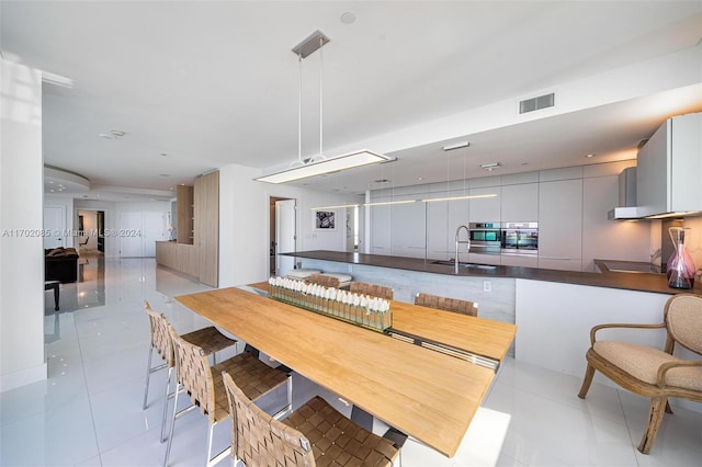 dining space with light tile patterned floors and sink