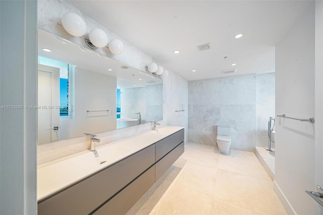 bathroom featuring tile patterned flooring, vanity, toilet, and tile walls