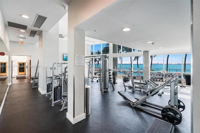 exercise room with a water view and a wall of windows