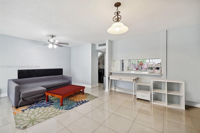 tiled living room featuring ceiling fan and a textured ceiling