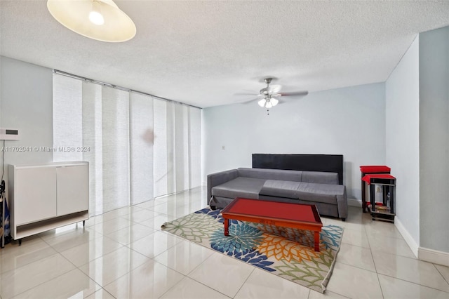 living room with light tile patterned floors, a textured ceiling, and ceiling fan