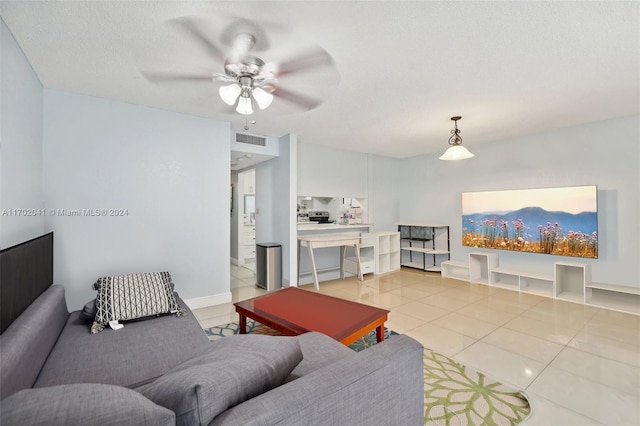 living room featuring light tile patterned floors, a textured ceiling, and ceiling fan