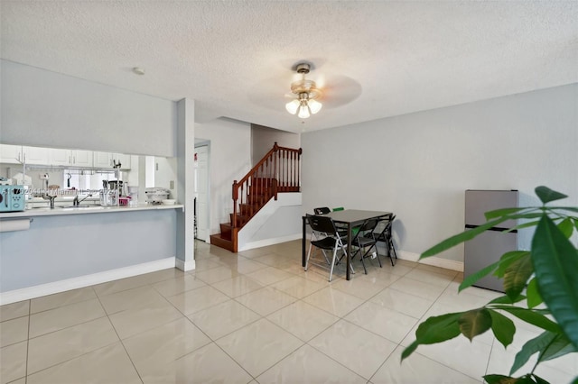 dining room featuring a textured ceiling, ceiling fan, and light tile patterned flooring