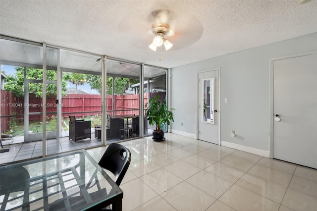 tiled home office featuring ceiling fan and a textured ceiling