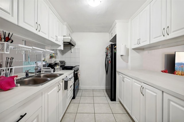 kitchen with tasteful backsplash, sink, black appliances, light tile patterned floors, and white cabinets