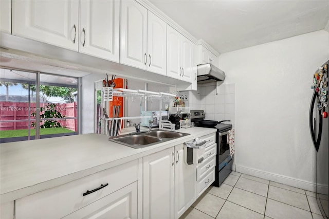 kitchen featuring sink, tasteful backsplash, light tile patterned flooring, white cabinets, and appliances with stainless steel finishes